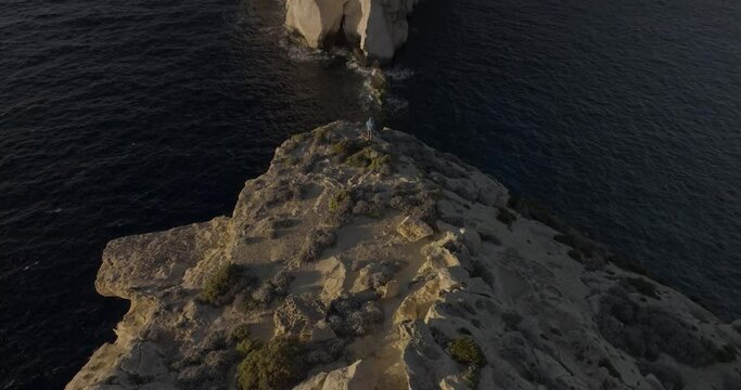 Aerial view of rugged cliffs and rocky shoreline overlooking the Mediterranean Sea, Gozo cliffs, Dwejra Bay, Munxar, Malta.