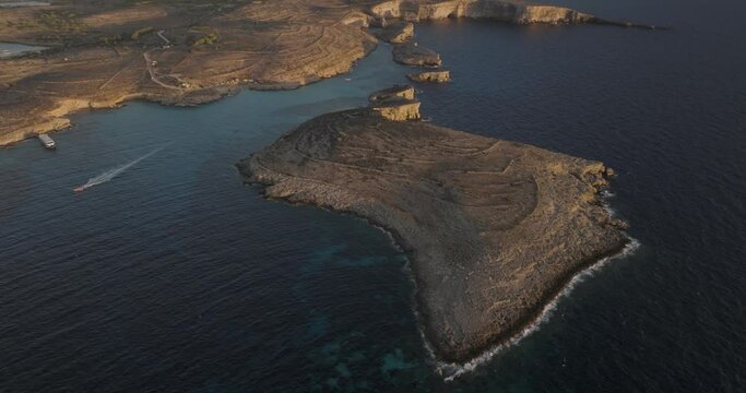 Aerial view of rugged Gozo cliffs and Comino island, Malta.