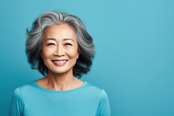 Cyan Background Happy Asian Woman Portrait of Beautiful Older Mid Aged Mature Smiling Woman good mood Isolated Anti-aging Skin Care Face Beauty Product Banner 
