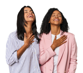 Young Latin businesswomen in studio laughs out loudly keeping hand on chest.