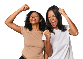 Young Latin friends in studio raising fist after a victory, winner concept.