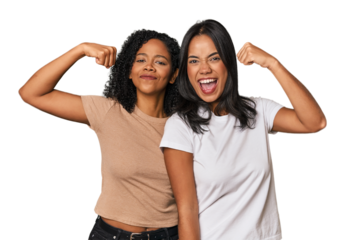 Young Latin friends in studio showing strength gesture with arms, symbol of feminine power