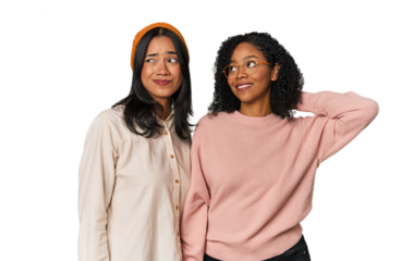 Young Latin friends together in studio touching back of head, thinking and making a choice.