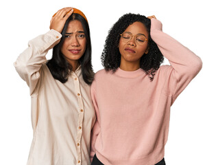 Young Latin friends together in studio tired and very sleepy keeping hand on head.