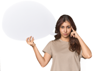 Middle Eastern woman holding comic bubble pointing temple with finger, thinking, focused on a task.