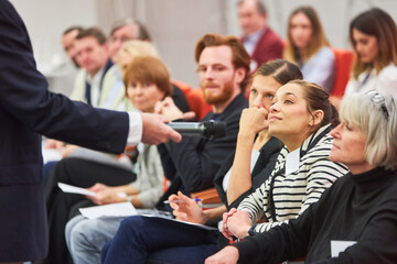 Speaker asking audience during business seminar in auditorium