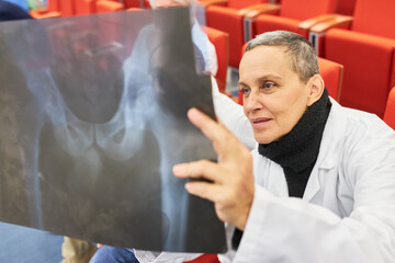 Doctors in audience examining medical x-ray at conference