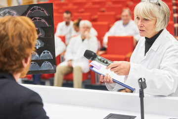 Doctor asking question to speaker during medical conference