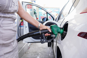 A woman is filling up her car with gas