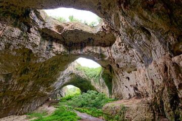 Obraz premium Devetashka Cave in Bulgaria. The Devetashka Cave is a truly spectacular natural phenomenon, imposing in size and unique in its shape.