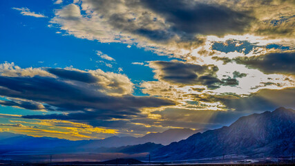 Dynamic sky over a mountainous landscape near Boulder City, Nevada at dusk.