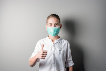 Cute boy in a white shirt showing thumbs up, ok sign.