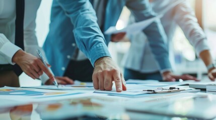 Obraz premium A group of people standing around a table with papers, suitable for business meetings or teamwork concepts