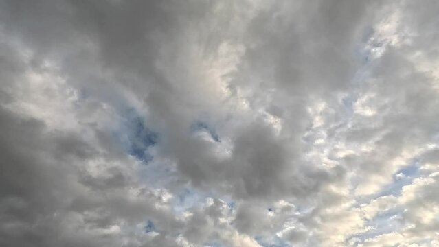 Scenery of thick gray clouds moving in blue sunny sky at the daytime