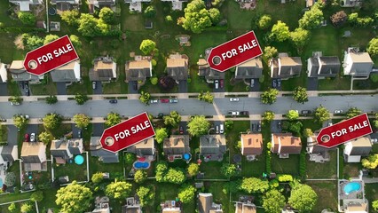 Neighborhood with multiple For Sale signs over homes. Top down aerial above modern American housing development. Graphic tags on houses. Real estate theme.