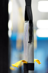 TRX training equipment hanging in gym, selective focus. Concept of sports, healthy lifestyle