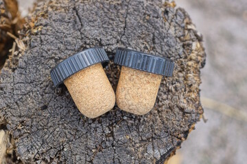 two brown black cork stoppers lie on a gray wooden table on the street