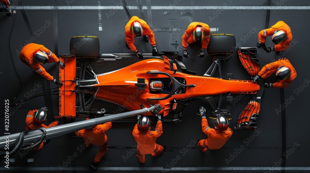 Wall mural high-angle view captures crew in orange suits working swiftly on race car. team's actions precision 