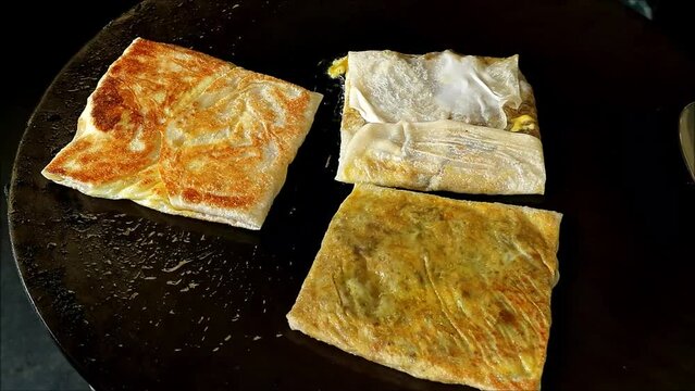 Footage of Cooking Roti Mataba or Murtabak, a Flavorful Pan Fried Spiced Beef Stuffed Pancake