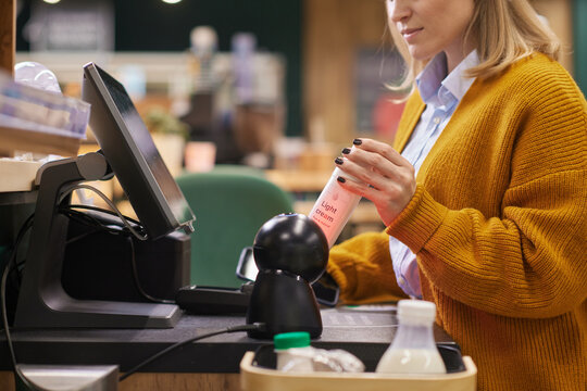 Close up of unrecognizable woman scanning dairy cream bottle while using self checkout  in supermarket copy space