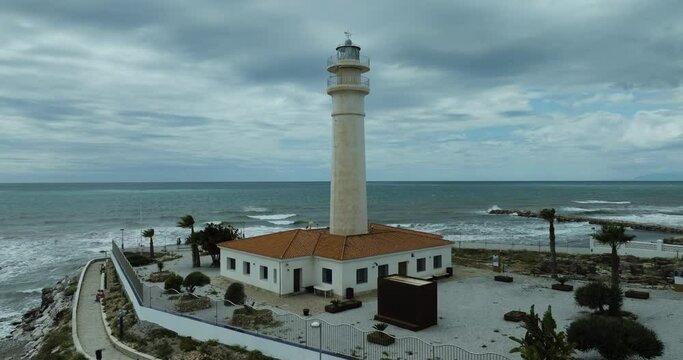 Aerial view of Torrox lighthouse by the sea with cloudy sky, Andalusia, Spain.