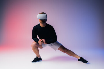 A man in a black shirt and white shorts stands confidently in a studio setting wearing a VR...