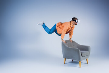 A man in an orange shirt showcases a mesmerizing trick on a chair, creating a captivating and...