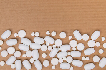 Tablets of white color, different shapes on a brown background. Copy space.