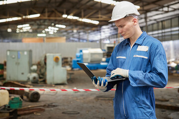 technician or engineer working on laptop computer in the factory