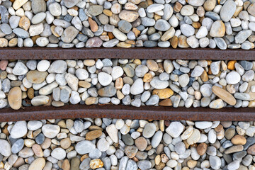 A detailed close-up image showcasing a variety of smooth river rocks in different shades and sizes,...