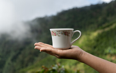 palma de mano con una taza de café al aire libre 