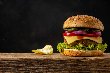 View of fresh tasty burger on wooden rustic table. Food background.