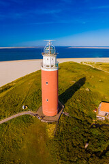 A majestic lighthouse stands tall against the shoreline, overlooking the vast expanse of the beach...
