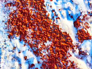 Red pebbles or rubberized textured material and white snow on it. Background, texture, frame, copy...