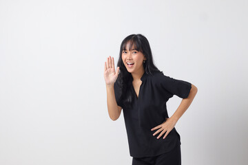 Portrait of attractive Asian woman in casual shirt raising hand, greeting and saying hi....