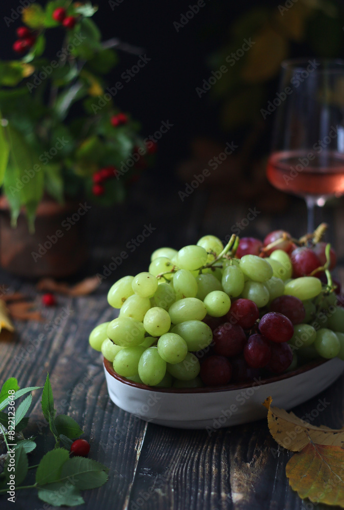 Wall mural A bowl with red and green grape in rustic style