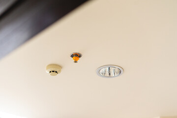 smoke detector and fire sprinkler,  on a ceiling, safety protocol for fire and life safety.