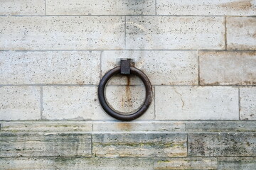Wall mooring ring, rusty metal. An old and rusty mooring ring is attached to a light wall of the...