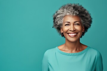 Teal Background Happy black american independant powerful Woman. Portrait of older mid aged person beautiful Smiling girl Isolated on Background ethnic diversity 