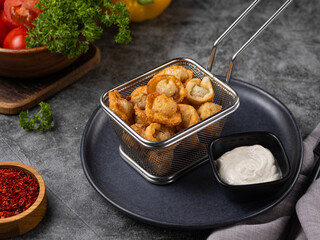 Fried dumplings with meat and herbs. Ravioli with a dressing of freshly ground pepper and lemon. Sour cream sauce and fresh herbs. Delicious lunch on a gray background.