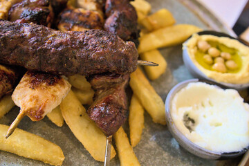 A platter of barbeque meat and chips with side dips