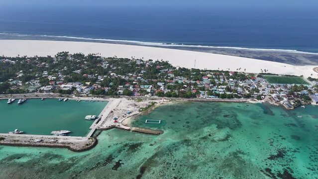 Aerial view of harbour, boats, houses, and reclamation in Addu City Development Project, Maradhoo, Addu Atoll, Maldives.