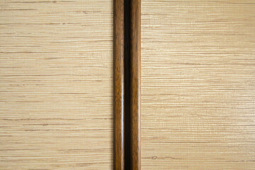 Wooden panel with horizontal grain pattern, divided by a darker vertical strip. 