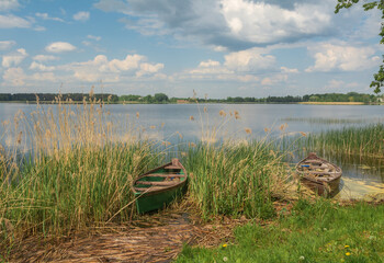 Obraz premium two old wooden boats on the shore of the lake.