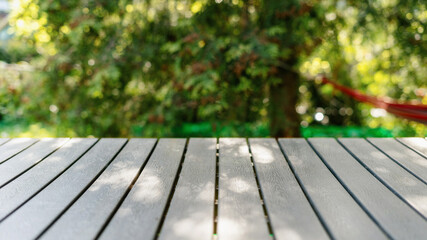 Picnic table in public park against green backdrop at sunny day