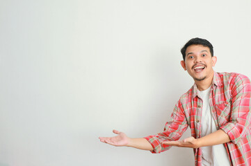 an asian man smiles and points to something with his hand