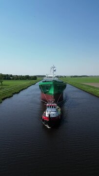Aerial video over a river in Appingedam  Netherlands on passing cargo ships