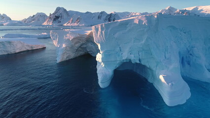 Huge icebergs blue cave, melting glacier in Antarctica. Large mass of ice floating polar ocean...