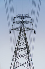 High voltage electricity tower on blue sky background.