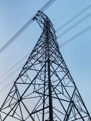 High voltage electricity tower on blue sky background.